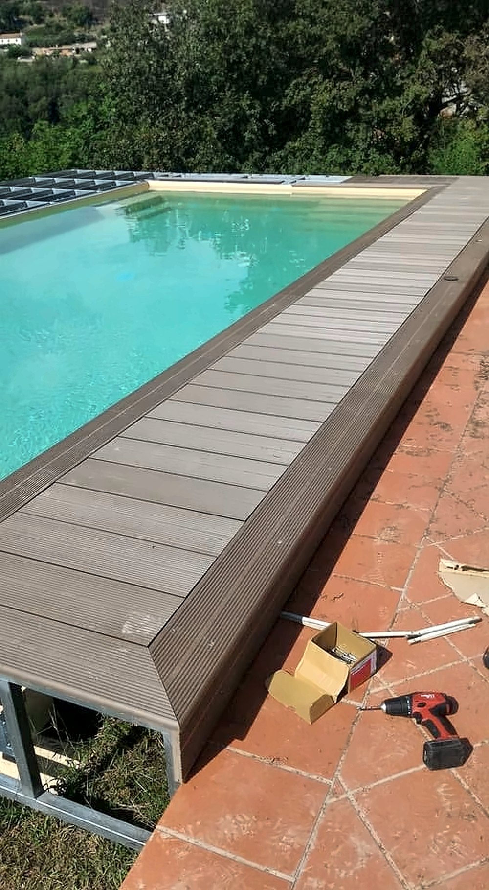 Piattaforma in acciaio zincato e rivestimento in legno composito attorno a una piscina