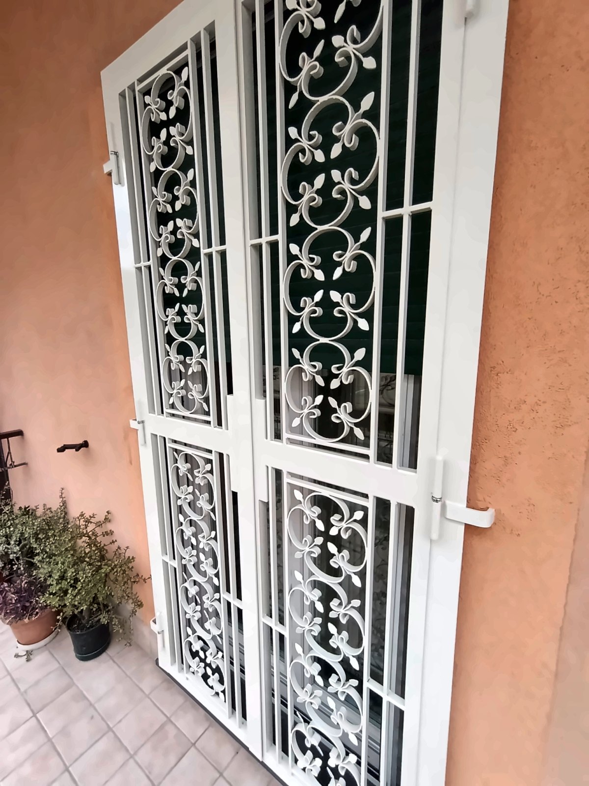 Grata di sicurezza bianca a due ante con decoro a ricci e gigli per portafinestra