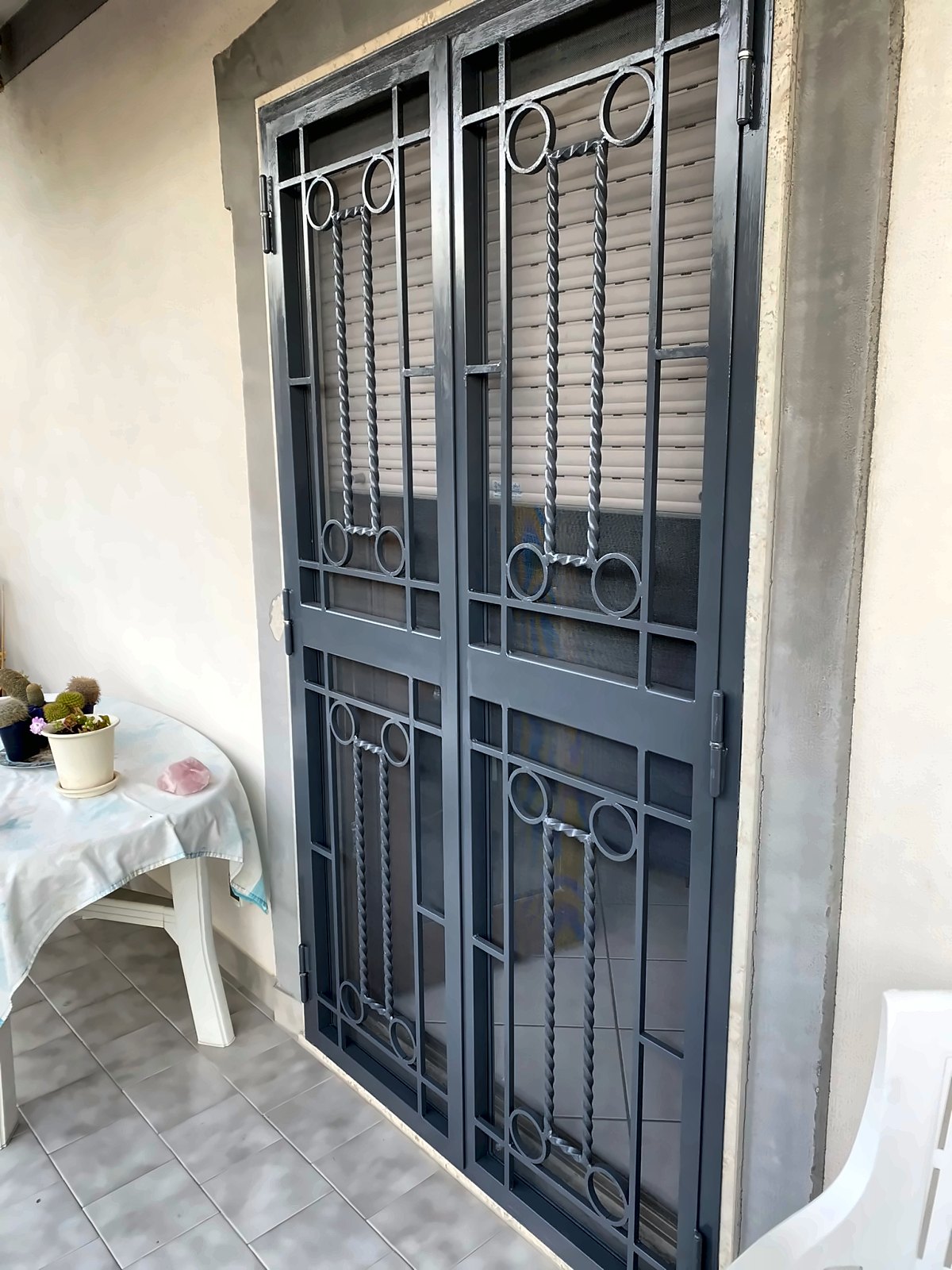 Grata a due ante in ferro grigio antracite con barre ritorte e cerchi, per portafinestra