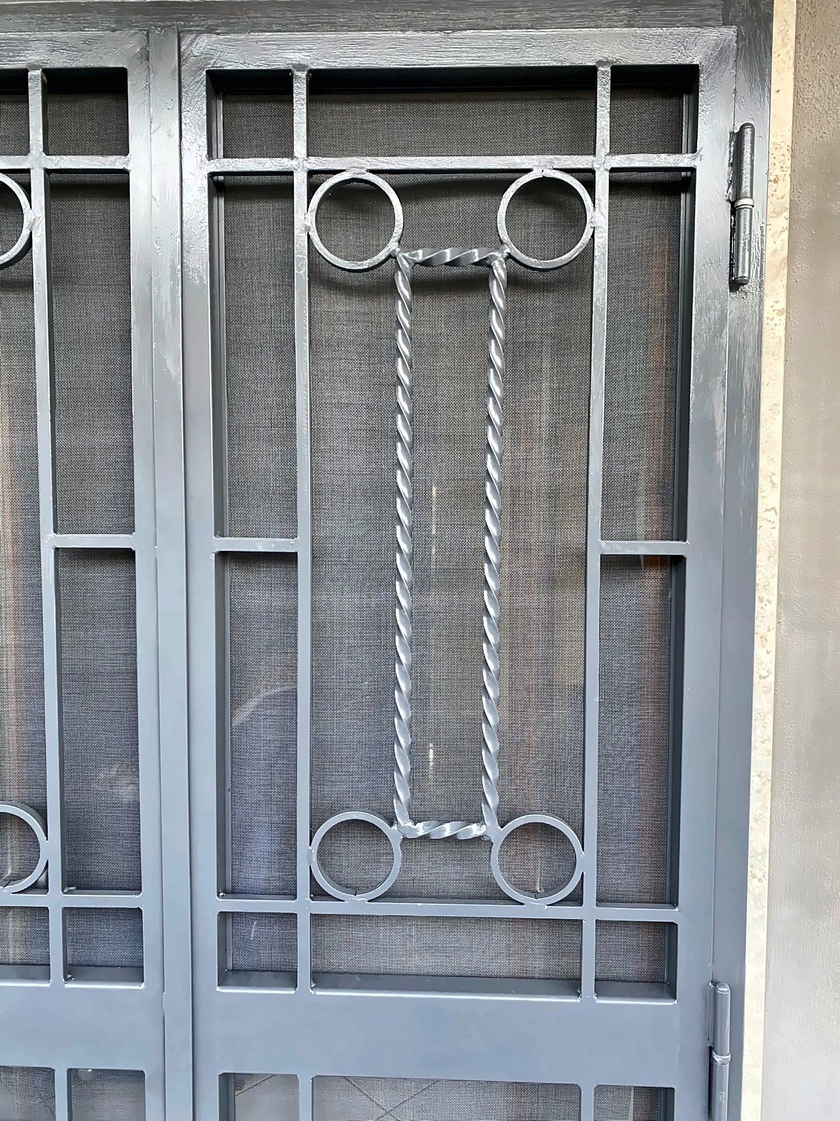 Dettaglio di una grata in ferro con barre ritorte e anelli saldati