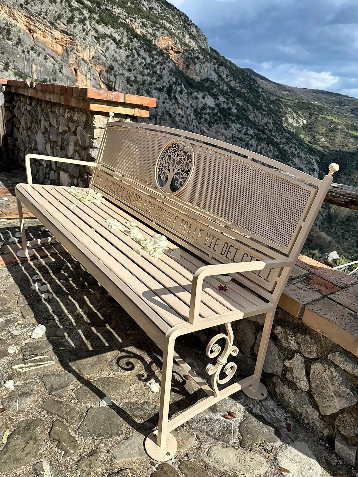 Panchina in ferro color crema, schienale con albero della vita e dedica incisa