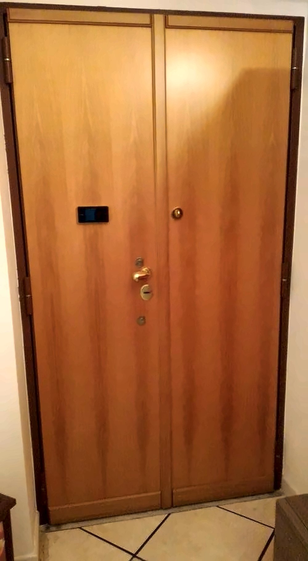 Porta blindata a due ante con finitura in legno chiaro