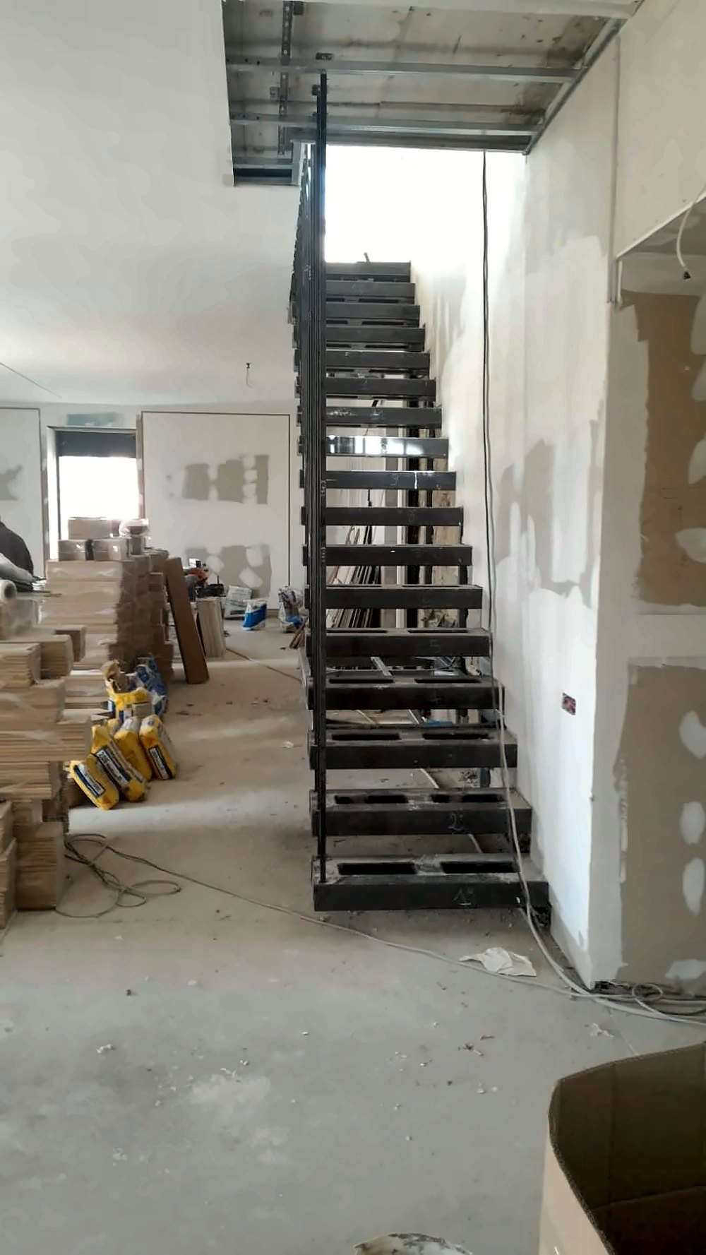 Scala in ferro a gradini sospesi con ringhiera a montanti, in fase di montaggio